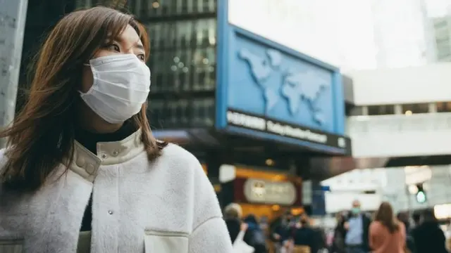 Mulher usando máscara na cidade