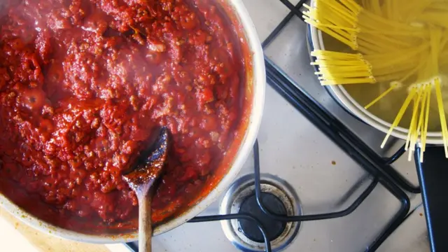 Uma panela com macarrão e outra com molho vermelho