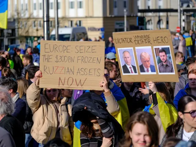 په بروکسل کې پر اوکراین د روسیې د یرغل د دریمې کلیزې په تړاو لاریون وشو، چې پرې لیکل شوي و "اروپا د روسیې ۳۰۰ ملیارده کنګل شوې شتمنۍ ضبط کړئ".