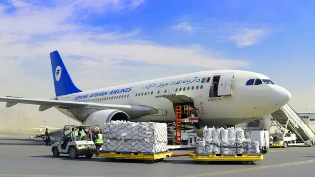 اموال تجارتی افغانستان در کنار یک هواپیمای شرکت آریانا در میدان هوایی کابل دیده می‌شود