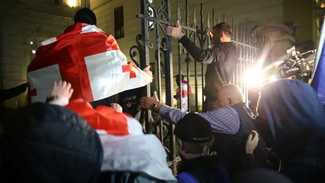 Демонстранты забрались на забор президентского дворца