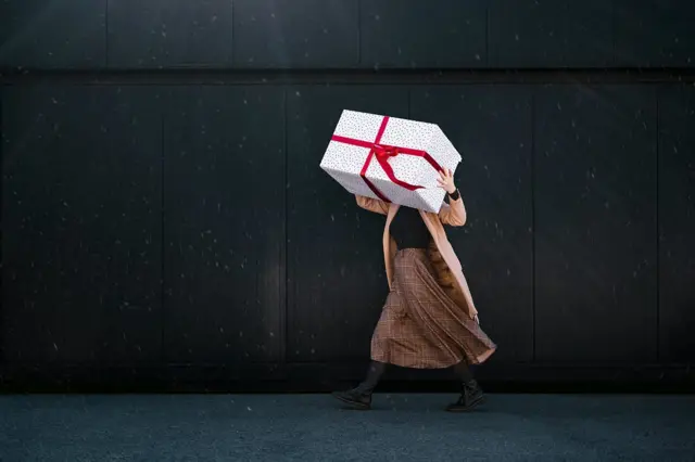 Mujer lleva caja de regalos