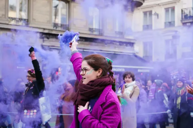 Una mujer con un bote de humo morado en una manifestación en Francia.