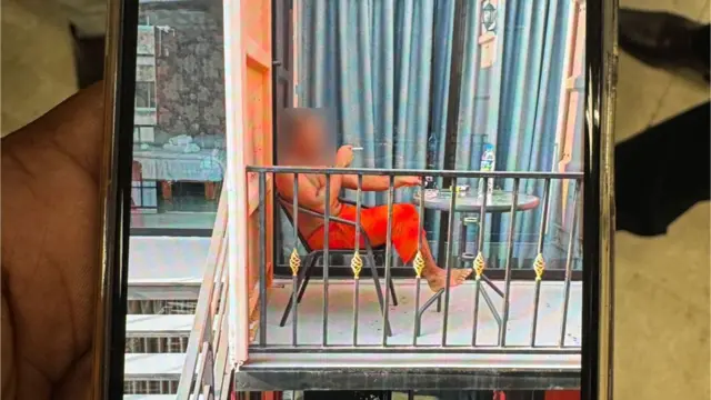 በበረንዳ ላይ ቁጭ ብሎ ሲጋራ የሚያጨስ መነኩሴ