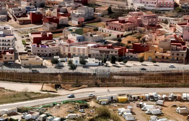 Una valla muestra la separación entre la ciudad marroquí de Nador (arriba) y la española Melilla (abajo).