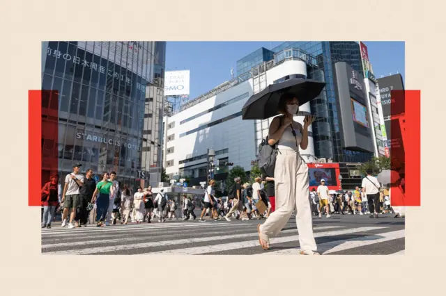 Une femme traverse un passage piéton à Tokyo.