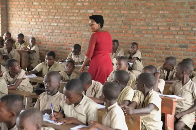 Abanyeshure barimo kwiga bari kumwe na mwarimu wabo mu ishure 