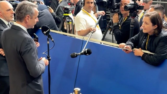 جسیکا پارکر در حال گفت‌وگو با کیریاکوس میتسوتاکیس، نخست‌وزیر یونان