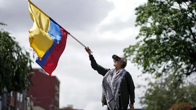 Женщина в очках, куфие и с флагом