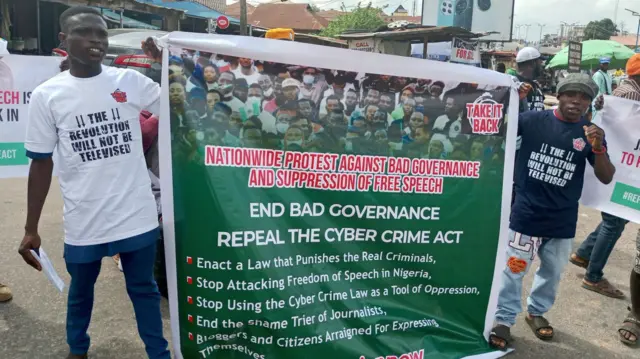 Two men holding a banner