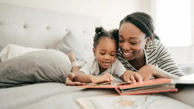 Madre e hija leyendo en la cama.