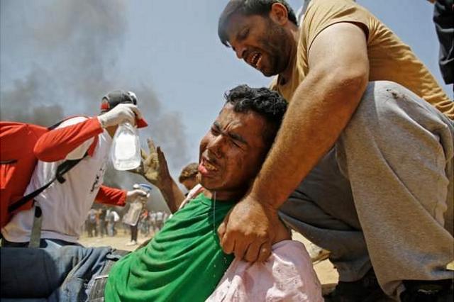 Палестинец поднимает раненого товарища
