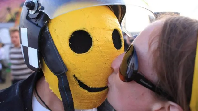 فتاة تقبل قناعا يرتديه شاب على وجهه