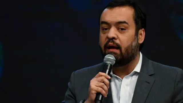 Fotografia colorida mostra Claudio Castro, um homem de cabelo preto e barba preta