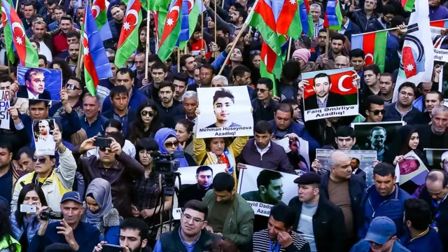 На митинге в защиту политзаключенных. Фото Гусейнова держит женщина в центре