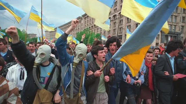 Демонстранти на Хрещатику з прапорами України в протигазах