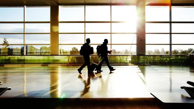 Personas caminando por un aeropuerto