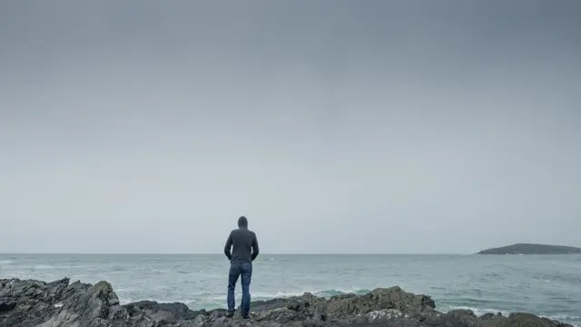 Hombre de espaldas frente al mar
