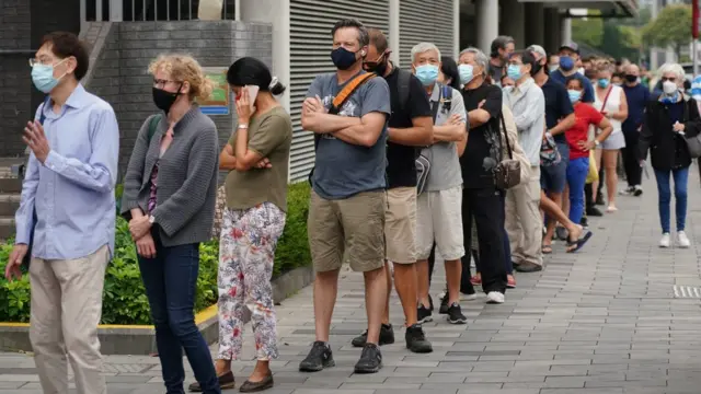 香港市民在西区中山纪念公园体育馆社区疫苗接种中心门前排起长龙准备接种复必泰疫苗（中新社图片5/4/2021）