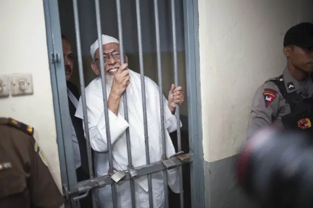 Abu Bakar Ba'asyir tersenyum di balik jeruji besi Pengadilan Negeri Jakarta Selatan, sebelum mendengarkan sidang putusan kasus terorisme yang menyeret namanya tahun 2011 lalu.