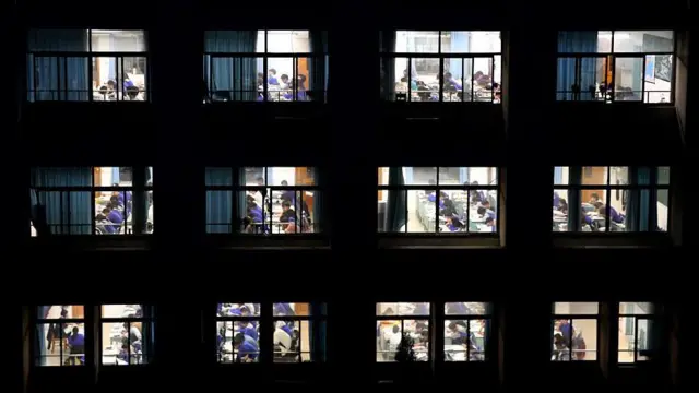 夜间校舍的广角画面，教室窗户透出学生正在学习的景象。