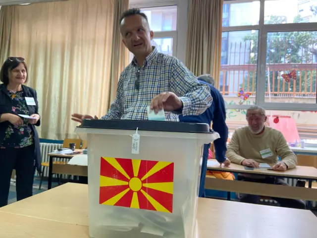 Čovek ubacuje glasači listić u kutiju