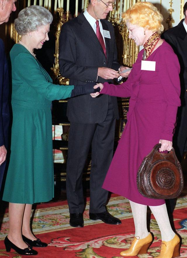 La reina Isabel II estrechando la mano de Dame Vivienne Westwood en el Palacio de Buckingham, Londres en marzo de 1999.