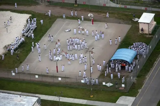 نمای هوایی از یک کمپ نگهداری پناهجویان، شمار زیادی با لباسهای سفید در محوطه باز ایستادهاند