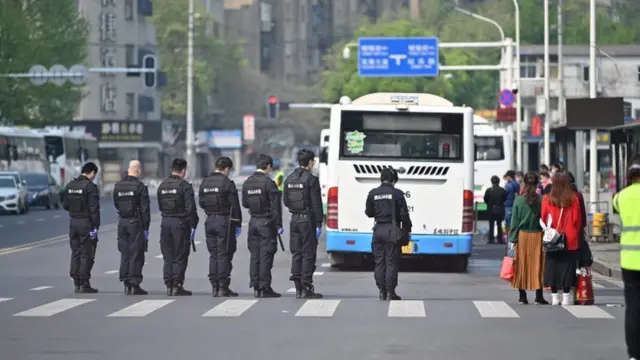 Police officers and officials stop and pay their respects during a three minutes of silence to mourn those who died in the fight against the pandemic