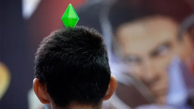 Мужчина с значком игрока The Sims на Electronic Entertainment Expo в 2010 году.