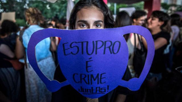Mulher segura cartaz, em formato de útero, onde se lê: Estupro é crime. Foto foi registrada durante protesto em SP em 2017 