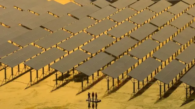 工人們在江蘇省泰州市的漁光互補項目上檢查設備，該項目漁業養殖與光伏發電相結合，在魚塘水面上方架設光伏板陣列，光伏板下方水域可以進行魚蝦養殖，光伏陣列還可以為養魚提供良好的遮擋作用，形成「上可發電、下可養魚」的業態。