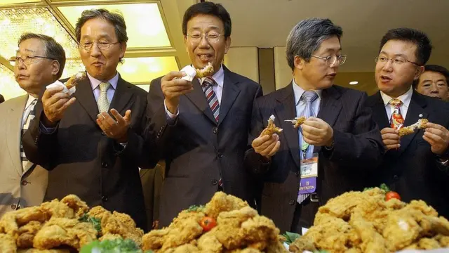 Four South Korean men, all family doctors, taste fried chicken at a hotel in Seoul in 2005 as part of a campaign to promote chicken sales