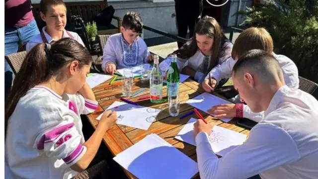 The six children drawing at a table