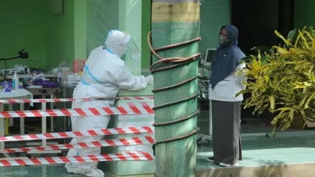 Petugas medis berkomunikasi di ruang isolasi COVID-19 RSUD Slamet Martodirjo, Pamekasan, Jawa Timur, Senin (21/06).