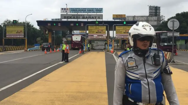 Petugas berjaga menghalau kendaraan berplat ganjil yang hendak masuk tol Bekasi Barat 1