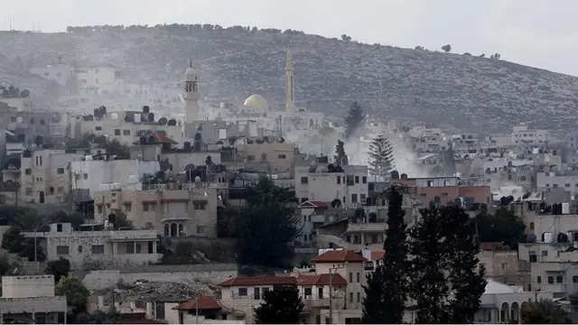 イスラエル軍が「対テロ」作戦を開始したパレスチナ自治区ヨルダン川西岸地区のジェニン難民キャンプから立ち上る煙（12日）