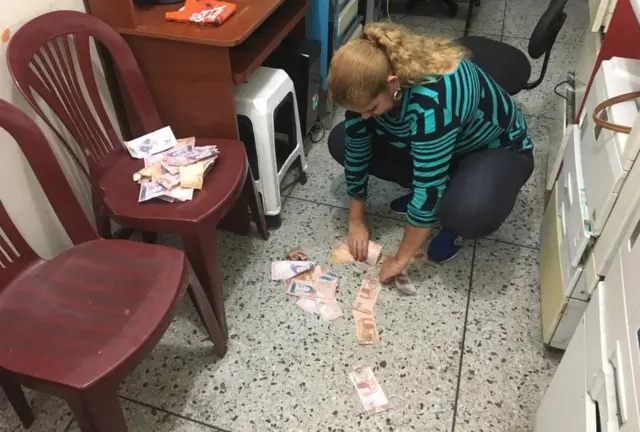 Yaneth recoge del suelo los billetes inservibles con los que ha estado jugando su nieto.