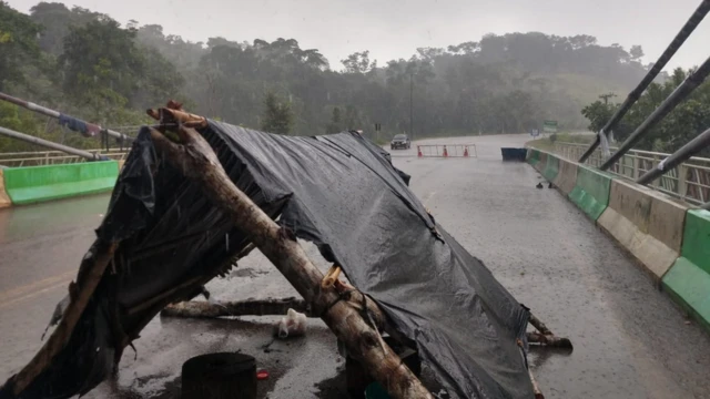 Barraca improvisada com troncos e plásticobet365 20 reaiscimabet365 20 reaisponte e sob chuva