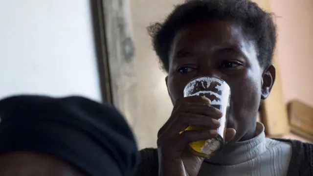 Женщина пьет пиво в шабине