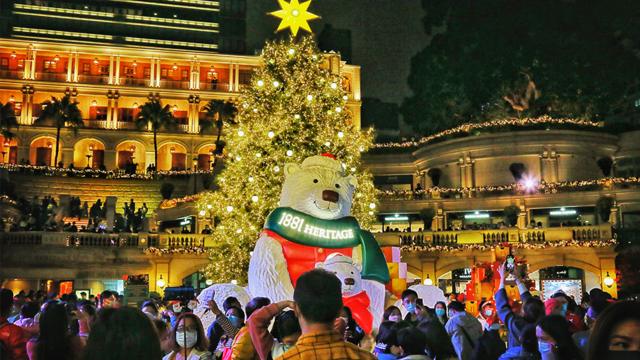 大批市民在尖沙咀一購物中心的聖誕裝飾前觀賞合照。