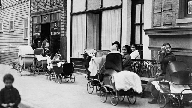 Mulheres e homens com carrinhos em frente à clínica Sanger