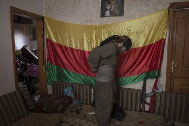 مبارز کرد کوبانی در حال آماده شدن برای رفتن به میدان رزم در جبهه شرقی شهر.اکتبر ۲۰۱۴