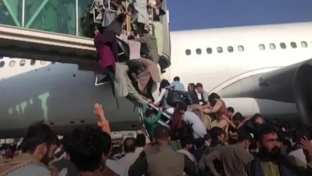 People climbing on to plane at Kabul airport