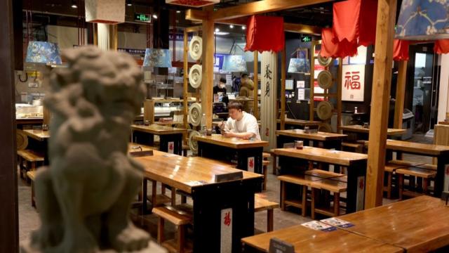 12月6日，防疫政策突然放開，北京一家空蕩餐館裏只有一位客人用餐。