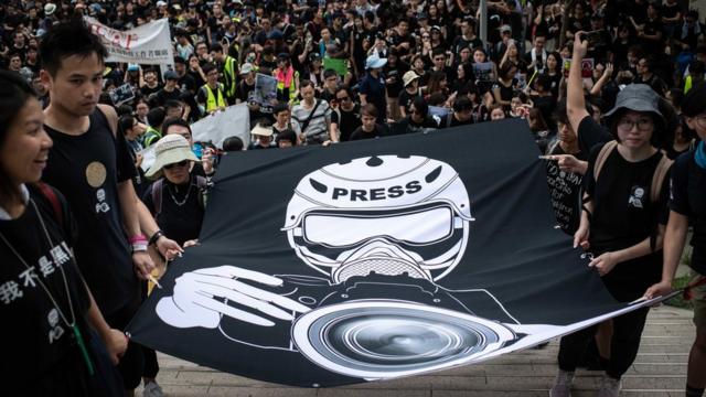 香港金钟记者工会与支持者举着象征记者在示威中采访之大型横幅游行抗议警察暴力对待（14/7/2019）