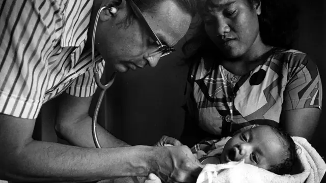 Doctor examinando un bebé mientras la madre observa