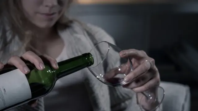 Woman pouring wine into glass