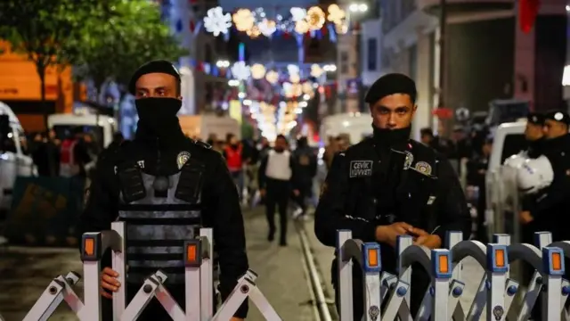 Police officers block the street after an explosion in Istanbul, Turkey