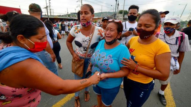 Mujeres lloran ante una cárcel de Ecuador tras la noticia de los amotinamientos
